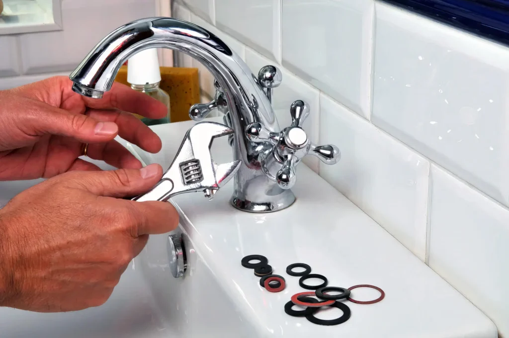 Plumber performing maintenance on a bathroom faucet in Erie