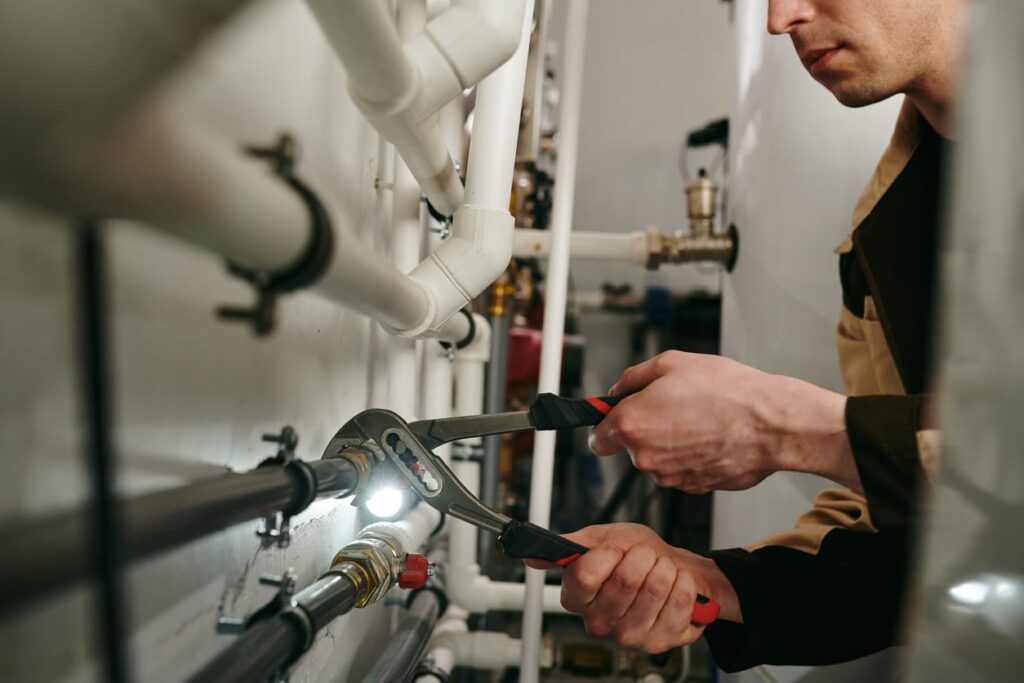 Plumbers maintaining commercial plumbing pipes in Erie