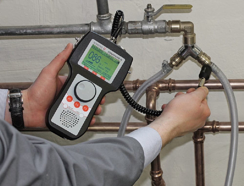 Plumber testing pipes with electronic leak detection equipment in Erie