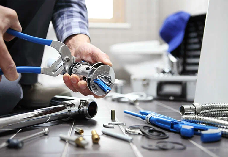 Technician repairing a plumbing fixture with professional tools in Erie