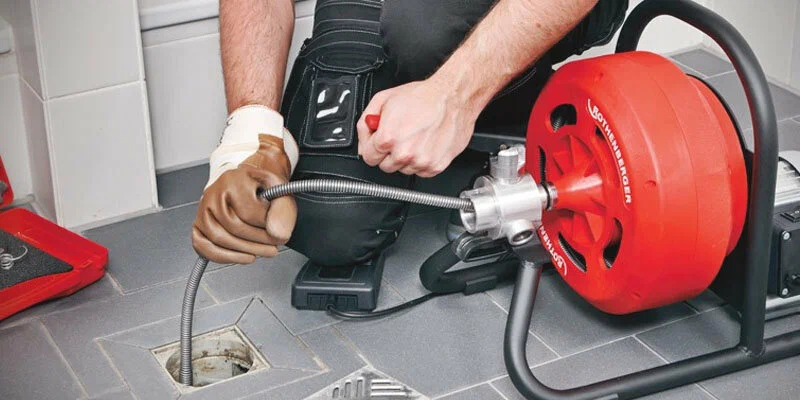 Plumber using a drain-cleaning machine in Erie