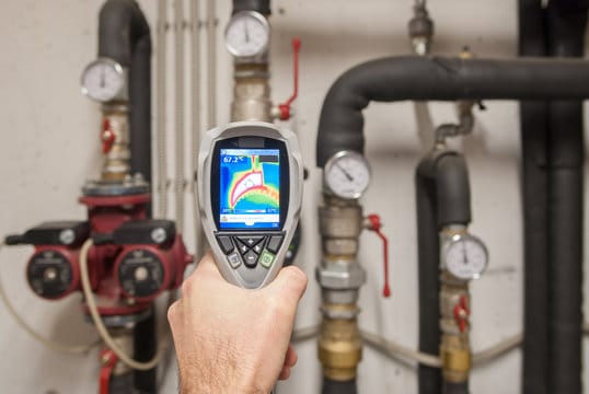 Plumber using a thermal imaging camera to inspect pipes in Erie
