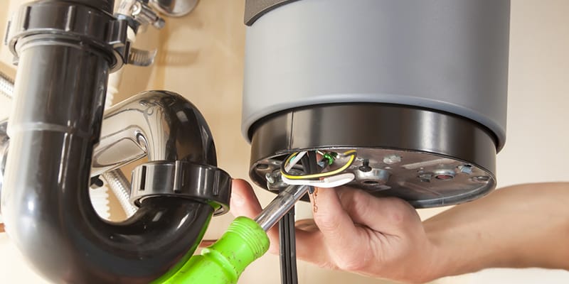 Technician repairing the heating element of a water heater in Erie