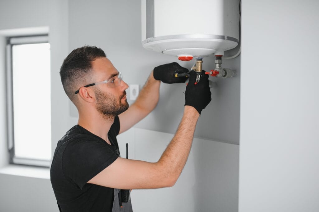 Technician performing water heater maintenance in Erie