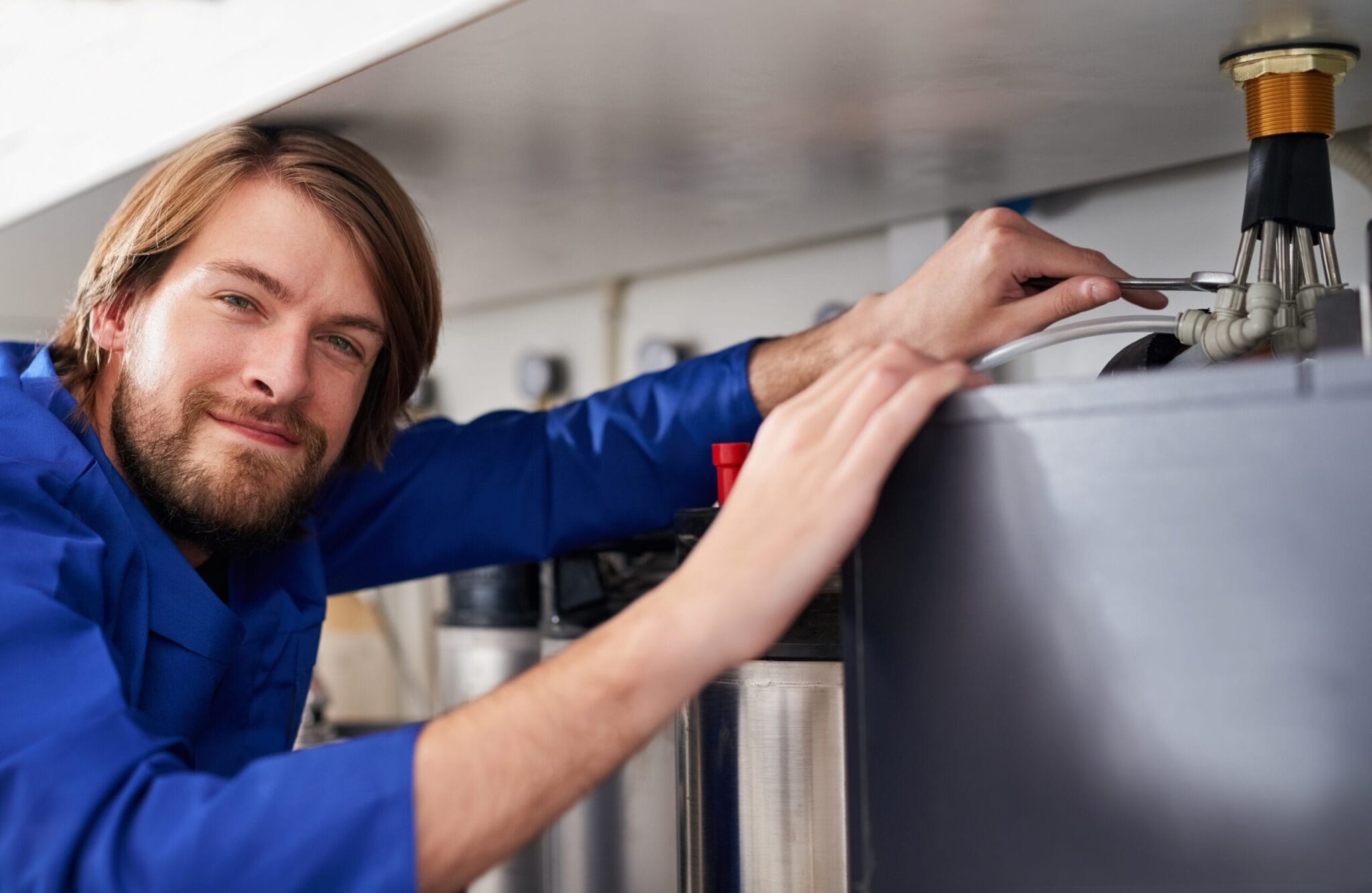Technician servicing a residential water heater tank in Erie