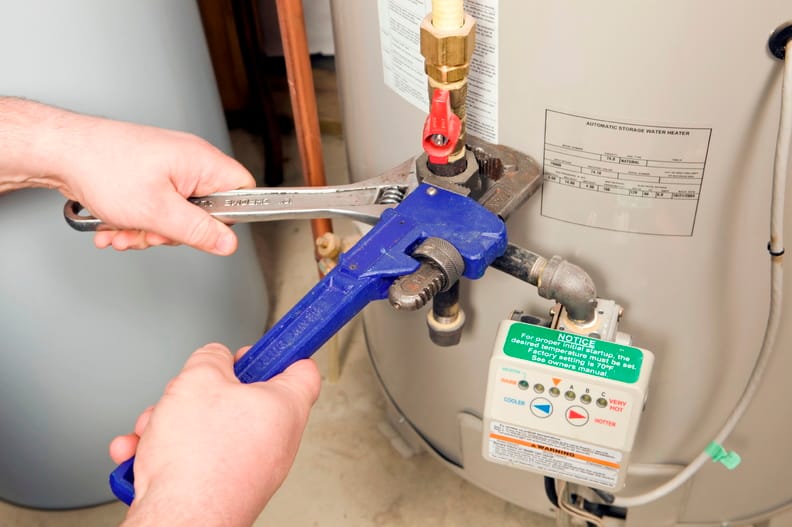 Plumber repairing a water heater valve in Erie